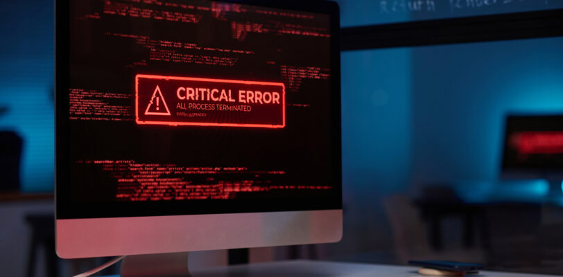 Background image of PC computer with emergency message of critical error on screen in red lights copy space